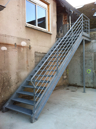 Fabrication et pose d'un escalier galvanisé avec palier pour accès à des bâtiments locatifs. Limon en VPN et marches anti-dérapantes
