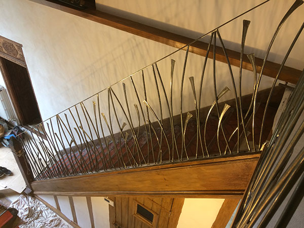Réalisation et pose d'une main courante d'escalier avec barreaux cintrés et appointis. Non peint avec vernis uniquement