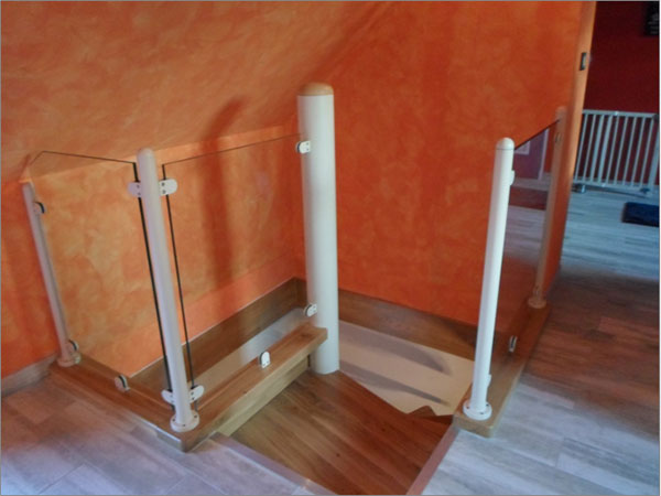 Fabrication et pose d'un escalier hélicoïdal : Palier composé de montants sur platine et d'agrafes pour la fixation du garde corps en verre