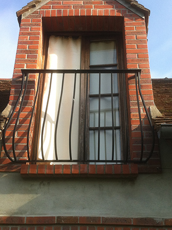 Garde corps pour fenêtre de toit, barreaudage cintré et main courante moulurée.